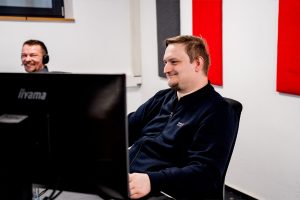 Blick auf einen Mitarbeiter von ewes & partner bei der Arbeit, im Hintergrund sitzt ein Kollege